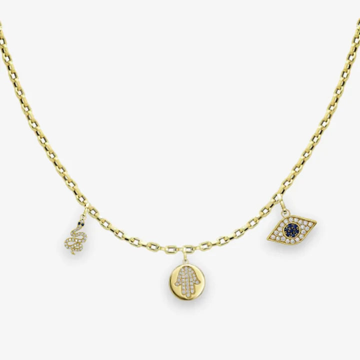 A gold chain with a small serpent charm, a pavé hamsa medallion and a protective eye charm