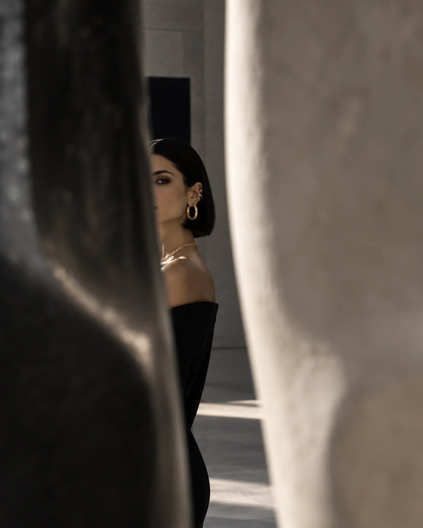 A woman wearing layered Ilene Joy necklaces in a private gallery